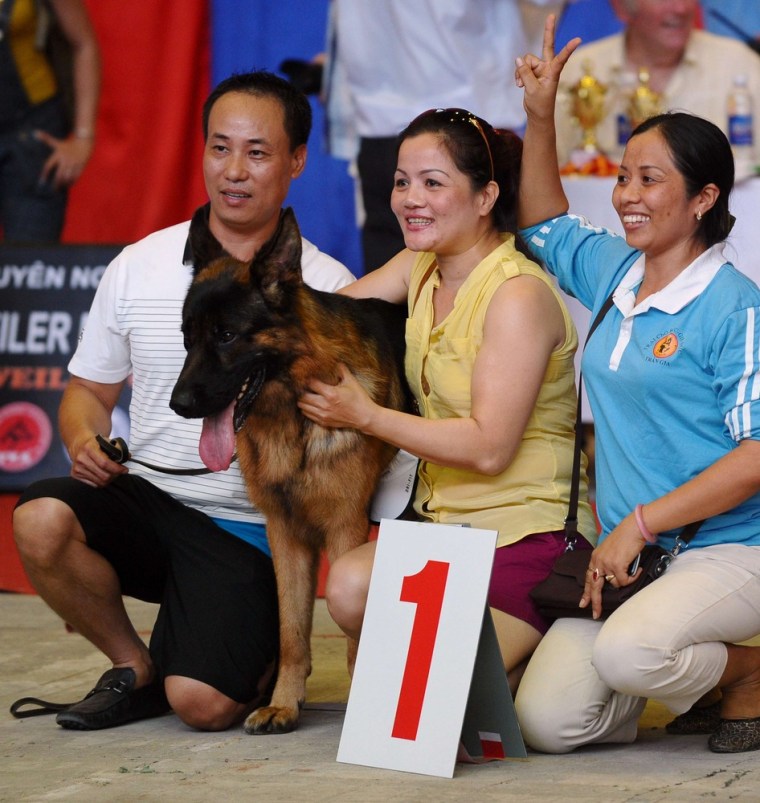 This picture taken earlier this month shows a family posing with their winning Leonberger dog at a dog show in Hanoi.