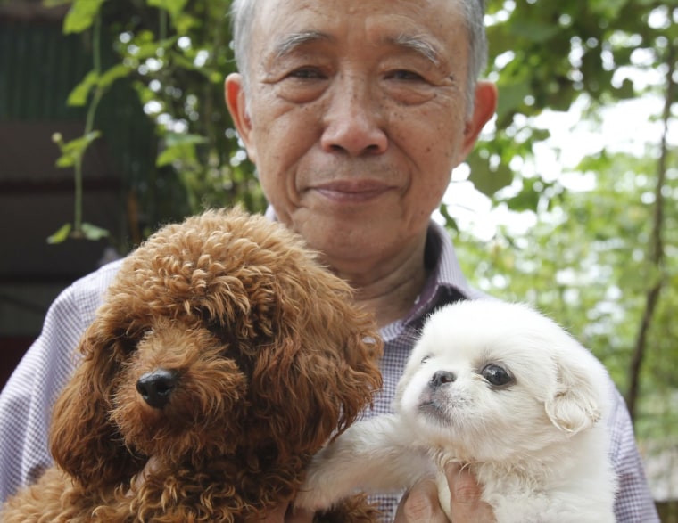Nguyen Bao Sinh, owner of the Bao Sinh Dog-Cat Resort, poses for a photo with dogs at his resort in Hanoi, October 5.