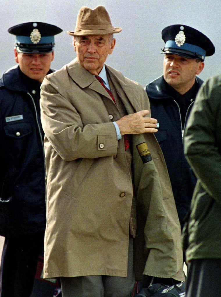Former Nazi SS Captain Erich Priebke is escorted by Argentine police as he prepares to board a flight taking him to Rome to face trial, in November 1995.
