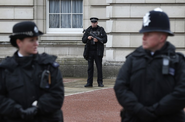 Image: British police officers guard the grounds of Buckingham Palace in London on Monday after a man armed with a knife tried to dart through a palace gate.