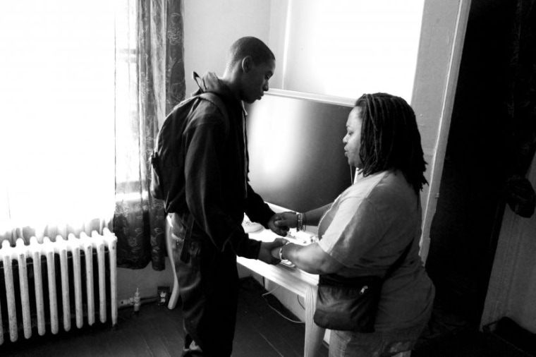 Khyrie Hawkins, 13, and his mother Dawn Hawkins pray in their Philadelphia home before the first day of school on September 9, 2013. Over the summer the Philadelphia school district closed 23 public schools, sending 9,000 students to new schools. Many of the students, like Khyrie, must now take longer and often more dangerous routes to school.