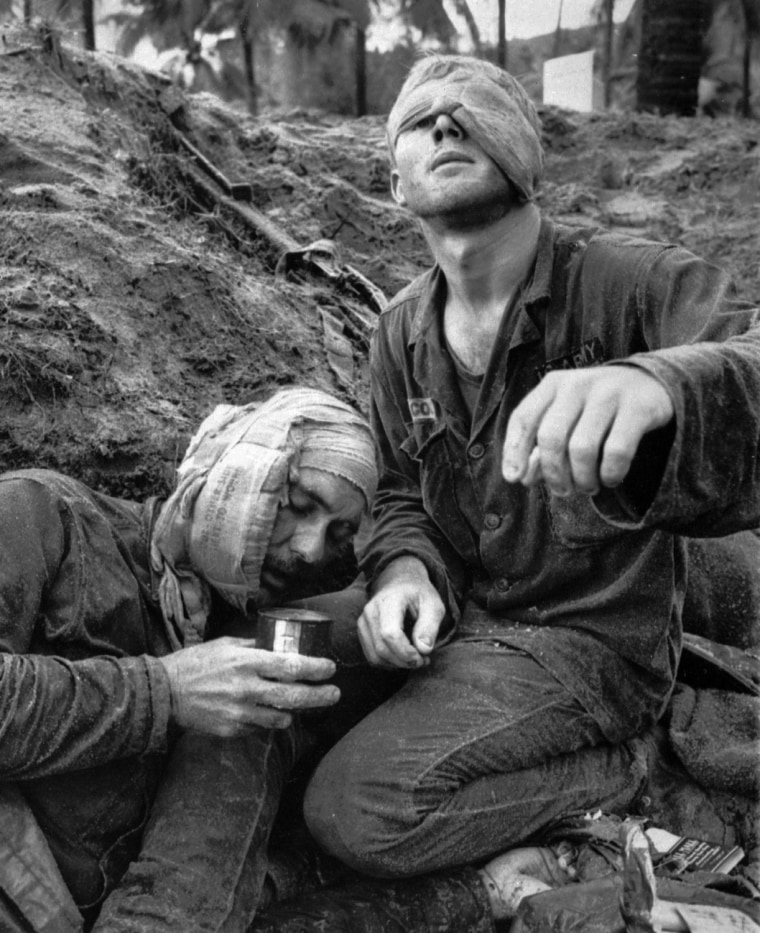 Medic Thomas Cole of Richmond, Virginia, looks up with his one unbandaged eye as he continues to treat wounded S.Sgt. Harrison Pell of Hazleton, Pennsylvania, during a firefight, January 30, 1966. The men belonged to the 1st Cavalry Division, which was engaged in a battle at An Thi, in the Central Highlands, against combined Viet Cong and North Vietnamese forces. This photo appeared on the cover of Life magazine, February 11, 1966, and photographer Henri Huet's coverage of An Thi received the Robert Capa Gold Medal from the Overseas Press Club. Huet was killed in 1971 when the helicopter he was traveling in with several other photographers was shot down over Laos.