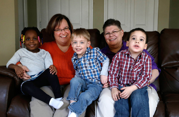 April DeBoer, second from left, sits with her daughter Ryanne, 3, left, and Jayne Rowse, fourth from left, and her sons Jacob, 3, middle, and Nolan, 4, right, at their home in Hazel Park on March 5, 2013. The couple's desire to adopt each other's children has grown into a ground-breaking challenge to Michigan's ban on same-sex marriage.