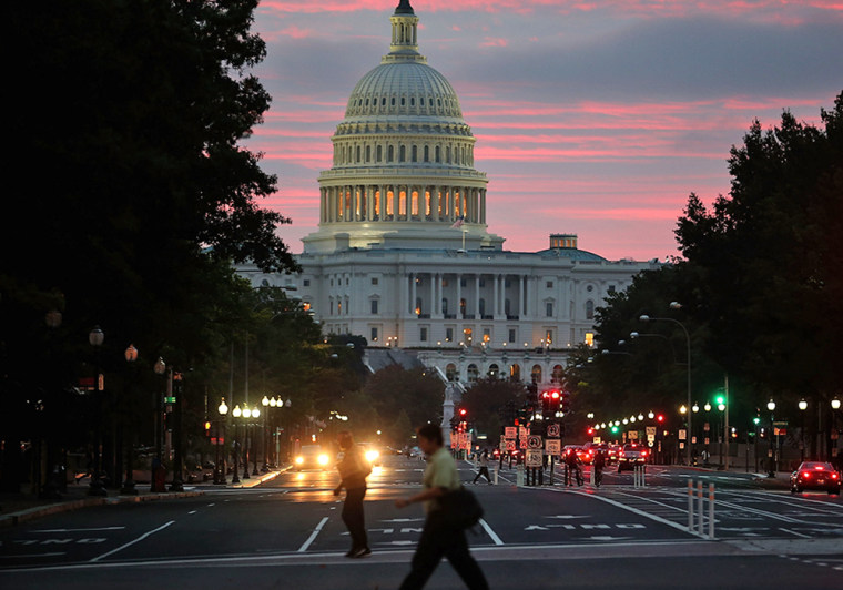 WASHINGTON, DC - OCTOBER 17: The sun begins to rise behind the U.S. Capitol building on the morning after a bipartisan bill was passed by the House a...