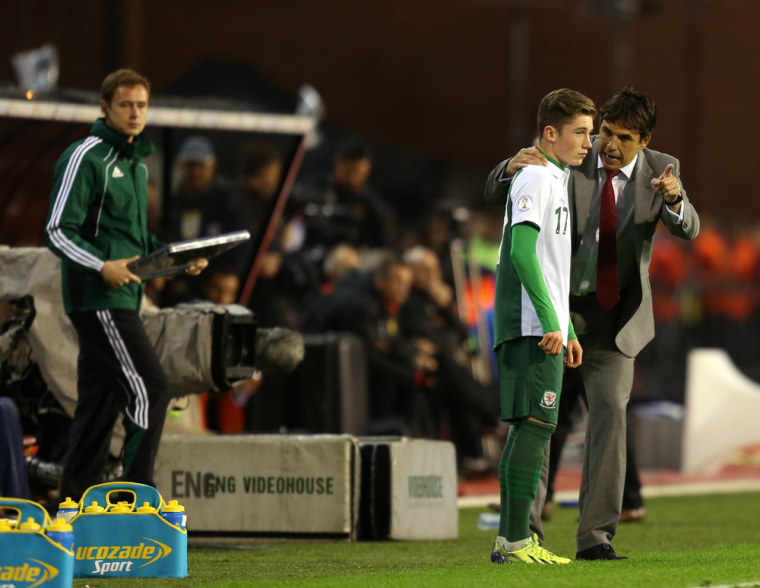 Wales soccer coach Chris Coleman gives instructions to Harry Wilson as he prepares to join the game - a move that won his grandfather $200,000.