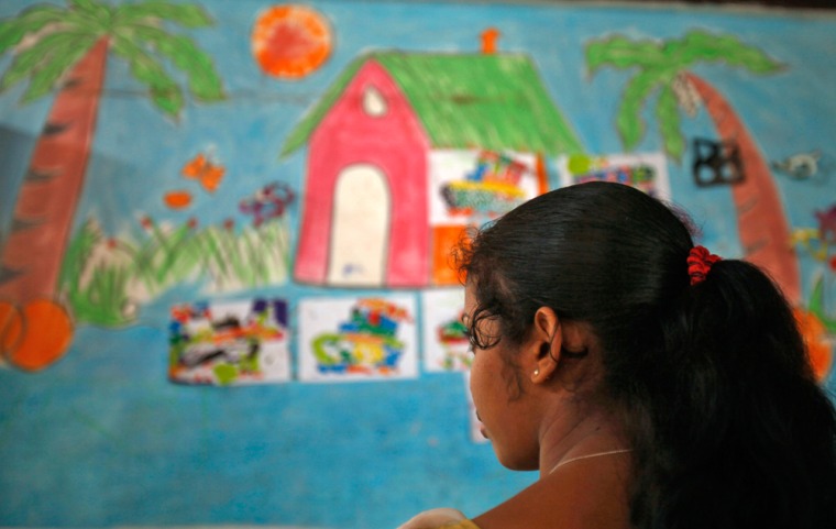 A 16-year-old girl stands inside a protection home on the outskirts of New Delhi, India, in November 2012 after being rescued by a charity from bonded labor.