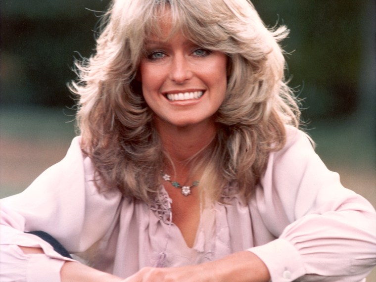 1975: (FILE PHOTO) Publicity portrait of American actor and model Farrah Fawcett smiling while sitting outdoors in blue jeans and a mauve blouse. Fawc...