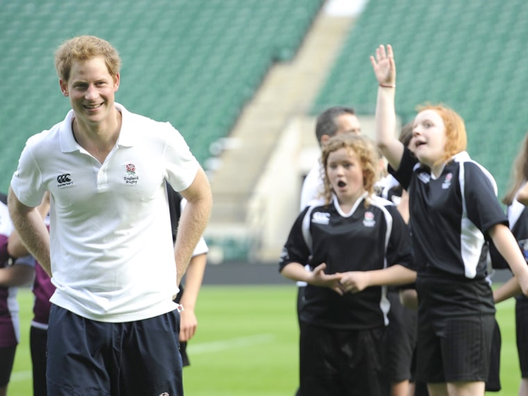Image: Prince Harry playing football with school children