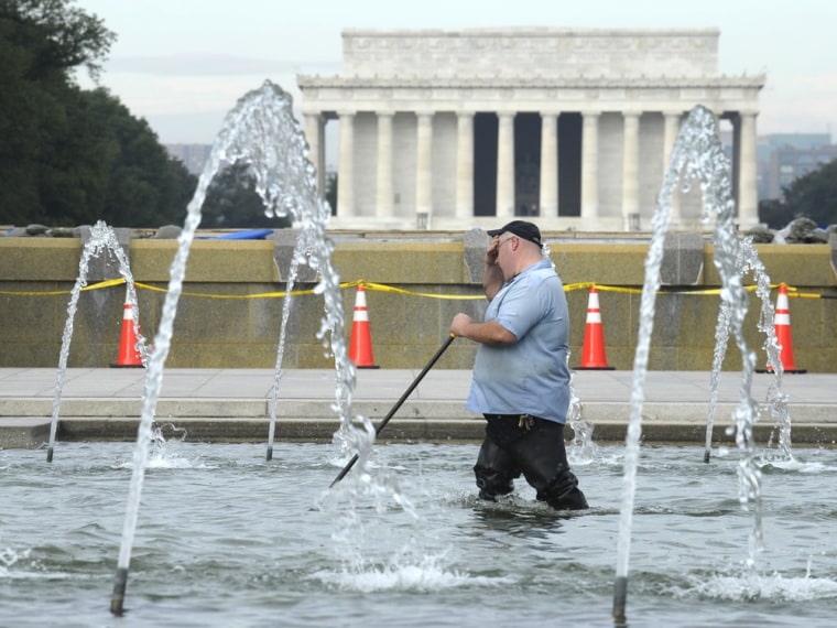 With the Lincoln Memorial in the distance, a worker cleans the fountain at the World War II Memorial in Washington, Thursday, Oct. 17, 2013. Barriers ...