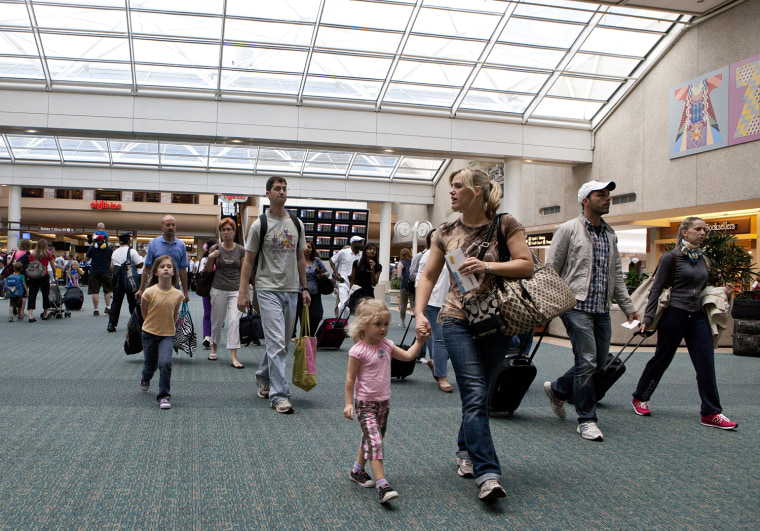 Travelers arrive at Orlando International Airport make their way to baggage claim in Orlando, Fla., in 2012.