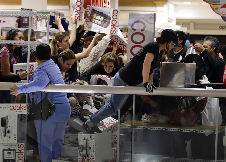 Shoppers rush to grab electric griddles and slow cookers on sale for $8 shortly after the doors opened at a J.C. Penney story, Friday, Nov. 23, 2012, ...