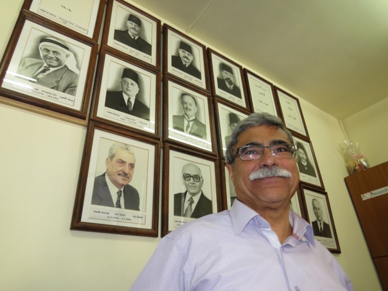 Nazareth's incumbent mayor Ramiz Jaraisy stands in his office in front of portraits of past mayors.