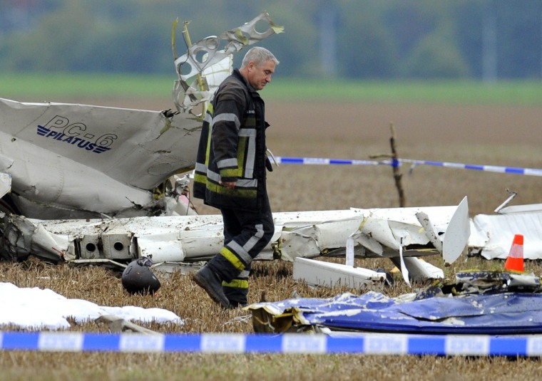A Belgian firefighter inspects the wreckage where a plane carrying 11 people crashed shortly after takeoff near Fernelmont, southeast of Brussels, on Oct. 19. All passengers on board were killed, the local mayor said.