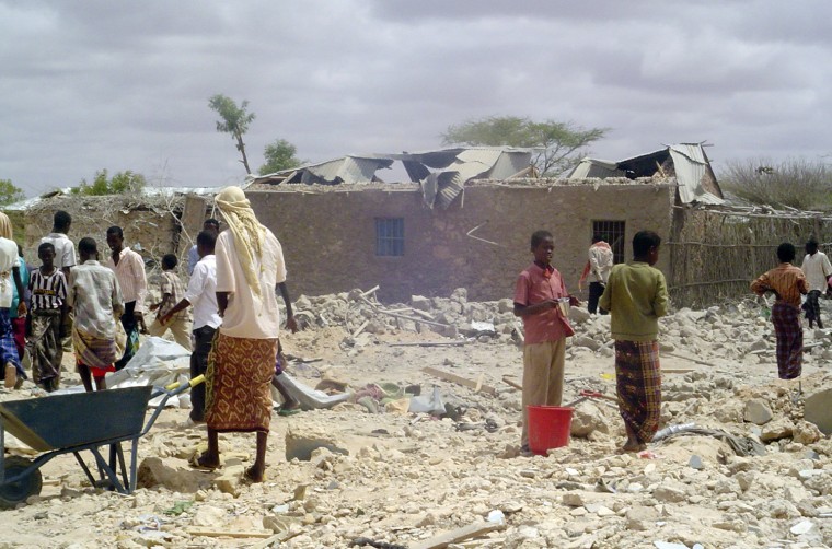 People walk through rubble after a U.S. missile killed al-Shabaab leader Aden Hashen Ayrow and as many as 30 other people on May 1, 2008, in Somalia.