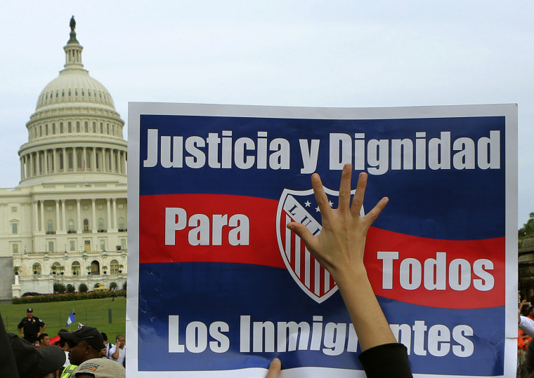 A woman holds up a sign during a protest rally for immigrants rights on Capitol Hill in Washington October 8, 2013. The sign reads