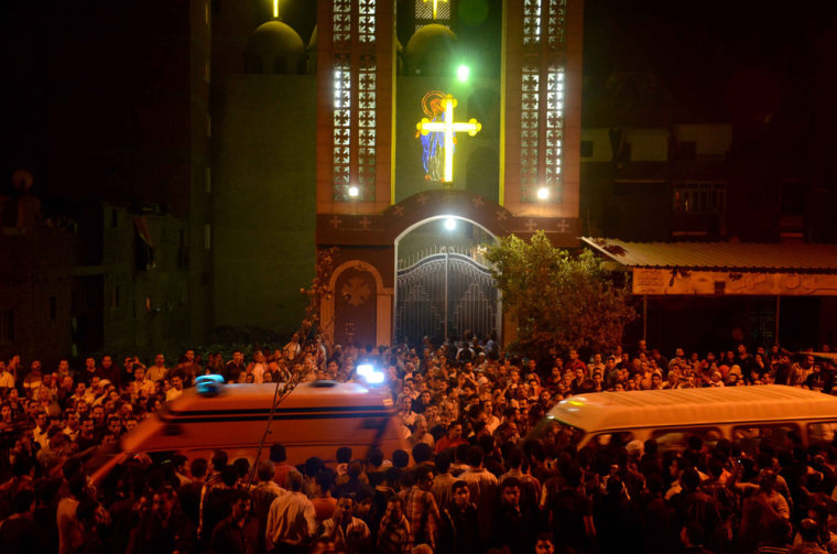 Ambulances drive through the crowd in front of the Virgin Mary Coptic Christian church in Cairo after gunmen shot dead three people late on Sunday.