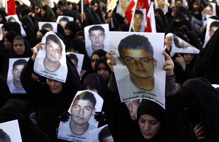Mourners hold pictures of Hussain Mahdi Habib during his funeral procession.