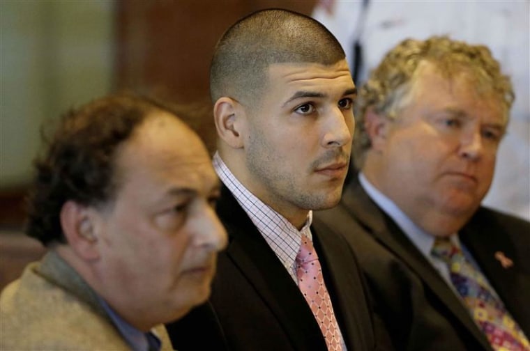 Former New England Patriots NFL football player Aaron Hernandez, center, sits with his attorneys James Sultan, left, and Michael Fee in Bristol Superior Court in Fall River, Mass., on Monday.
