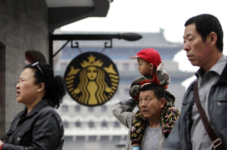 People walk past a Starbucks coffee store at Qianmen Commercial Street in central Beijing, in this file picture.