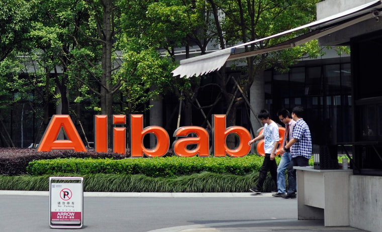 FILE - In this May 21, 2012 file photo, a group of men walk past the corporate logo at the headquarters compound of Alibaba Group in Hangzhou in easte...