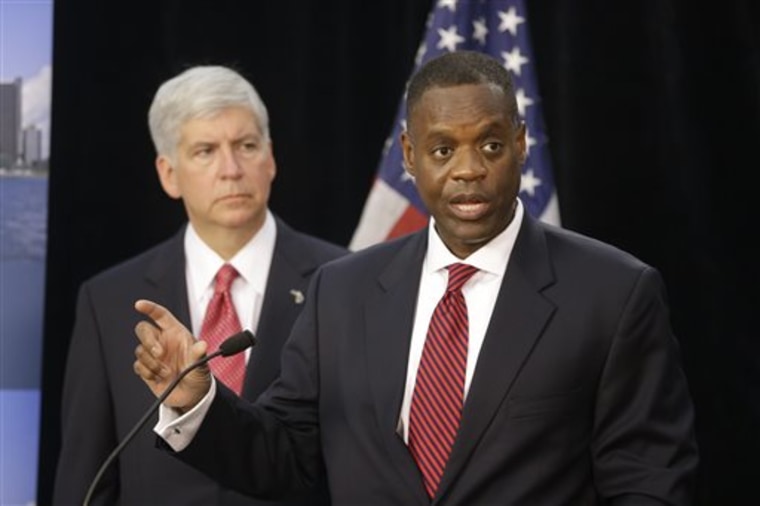 State-appointed emergency manager Kevyn Orr, right, and Michigan Gov. Rick Snyder address the media during a news conference in Detroit in this July 19, 2013, file photo. The city's bankruptcy case goes to trial Wednesday.