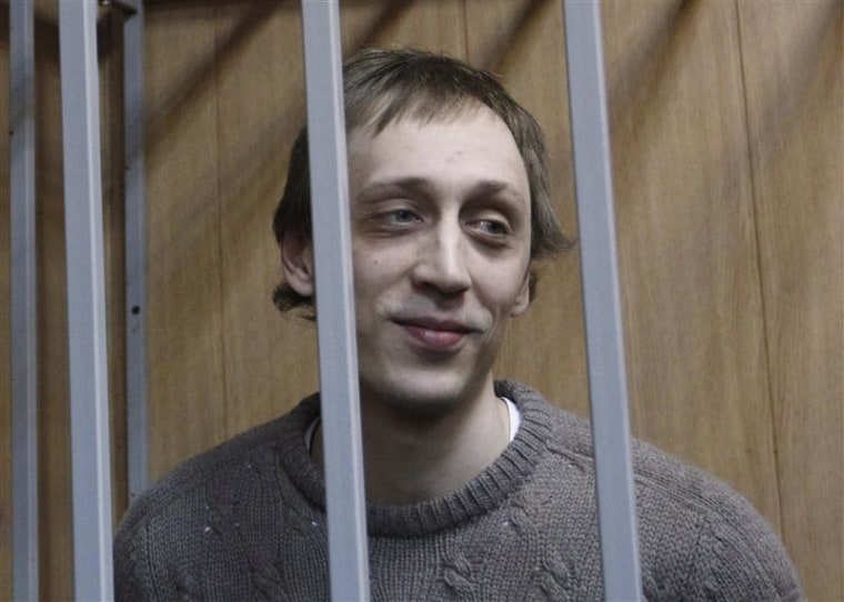 Dancer Pavel Dmitrichenko looks out from the defendant's holding cell during a hearing in Moscow on October 22, 2013.