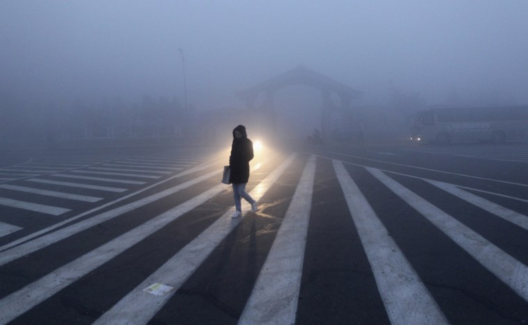 A woman walks along a street during a smoggy day in Changchun, Jilin province, China, on Oct. 22.
