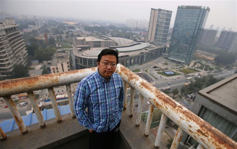 Chinese cartoonist Wang Liming poses on the balcony of his apartment before an interview with Reuters in Beijing, Ocotober 22, 2013. REUTERS/Petar Kuj...
