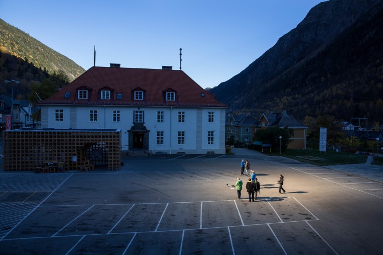 People gather on a spot in front of the town hall of Rjukan, Norway, Oct. 18, 2013, where sunshine is reflected by three giant mirrors erected on the mountainside above the industrial town.
