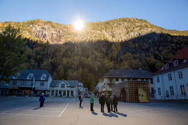People gather on a spot in front of the town hall of Rjukan, Norway, Oct. 18, 2013, where sunshine is reflected by three giant mirrors.