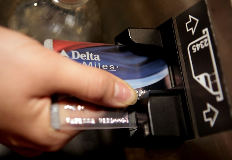 FILE - In this Dec. 14, 2007 file photo, a traveler uses a Delta SkyMiles credit card to buy an airline e-ticket at the Bob Hope Airport in Burbank, C...