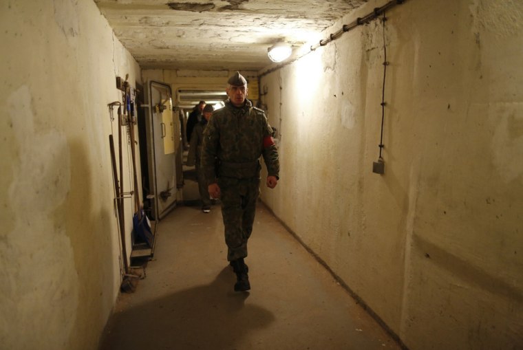 Marco, dressed as an NVA officer, walks inside the bunker.