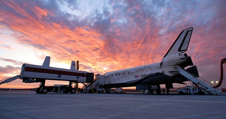 As the sun sets over Edwards Air Force Base in California, astronaauts leave the shuttle Discovery at the end of a 14-day mission to the International Space Station on Sept. 11, 2009. The mission marked the 25th anniversary flight of Discovery since its maiden space voyage in 1984.