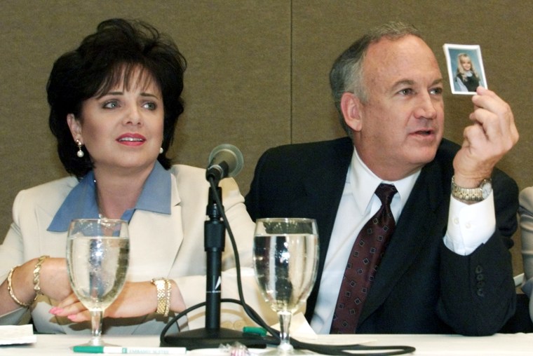 Patricia Ramsey and her husband, John Ramsey, produce a picture of JonBenet during a press conference in Atlanta, where they released the results of an independent lie detector test months after her death in 2000.
