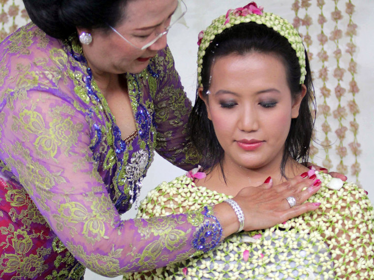 Yogyakarta Sultan Hamengkubuwono X's fourth daughter Princess Hayu, 29, covered with a cape of flowers is bathed with water during a purification ritu...