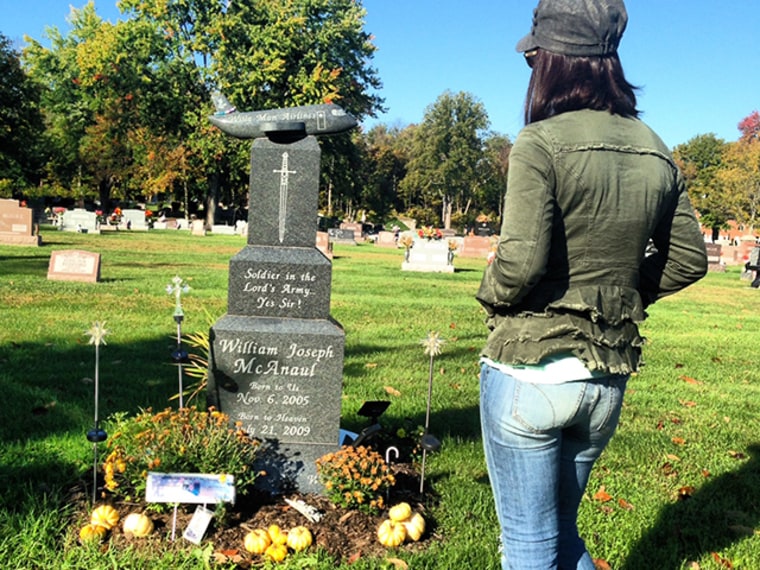 A woman visits the grave of Will McAnaul, a 4-year-old boy who died after a gun incident in 2009.