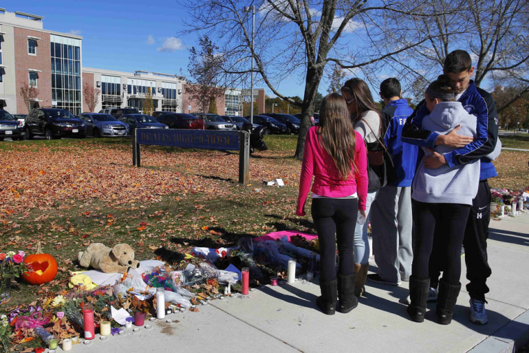 Students embrace at a makeshift memorial for teacher Colleen Ritzer outside the high school where she taught in Danvers, Massachusetts October 24, 2013.