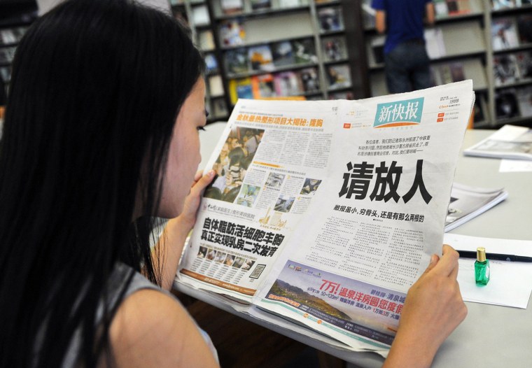 A woman reads the New Express newspaper that on October 23, 2013 carried a full-page editorial with headline