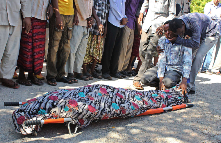 A relative is consoled as he mourns over the body of Somali journalist Mohamed Mohamud Timacade, on October 27, 2013, during his funeral after he succumbed to severe bullet injuries at a hospital in the capital, Mogadishu.