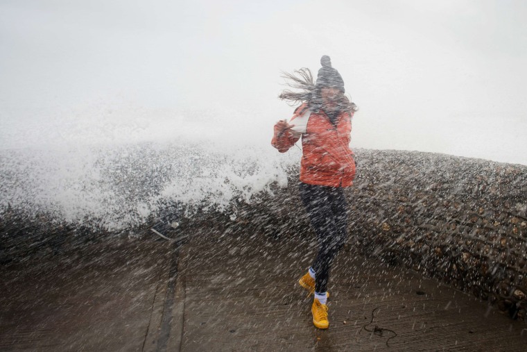 A woman is soaked as large waves crash against the walls of Brighton seafront, in southern England on Oct. 27, 2013 as a storm starts to build.