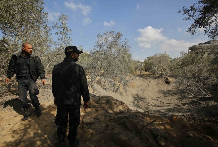 Palestinian policemen loyal to Hamas inspect the scene of an Israeli air strike in the northern Gaza Strip on Monday after two rockets were fired from Gaza into Israel.