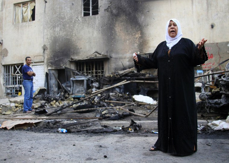 A woman grieves for her sister, who died in a bombing, while inspecting the site of the car bomb attack in Baghdad, Iraq on Oct. 19, 2013.