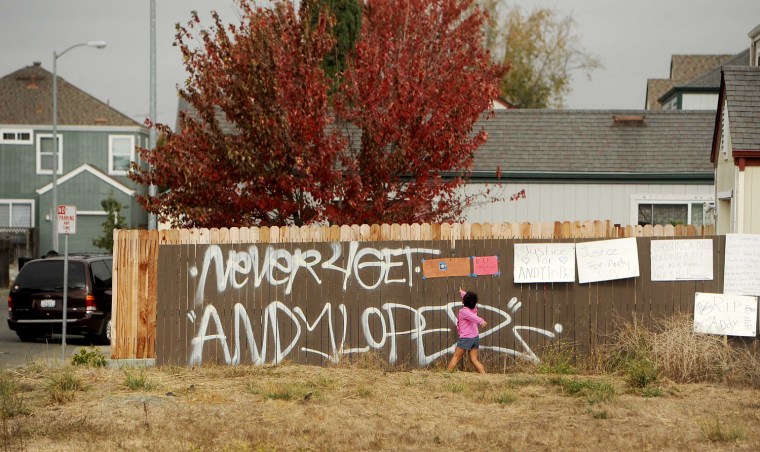 A girl reads signs in a vacant lot where 13-year-old Andy Lopez Cruz was shot and killed in Santa Rosa, Calif.