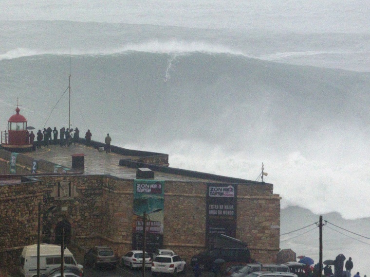 Brazilian surfer Carlos Burle rides a big wave at the Praia do Norte, north beach, outside the fishing village of Nazare in Portugal's Atlantic coast ...