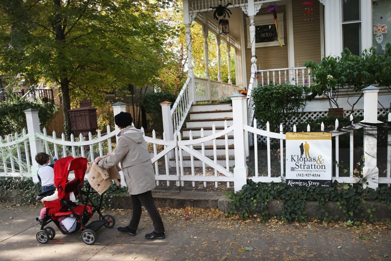 CHICAGO, IL - OCTOBER 28: A person pushes a stroller past a home that is offered for sale in the Wicker Park neighborhood on October 28, 2013 in Chi...