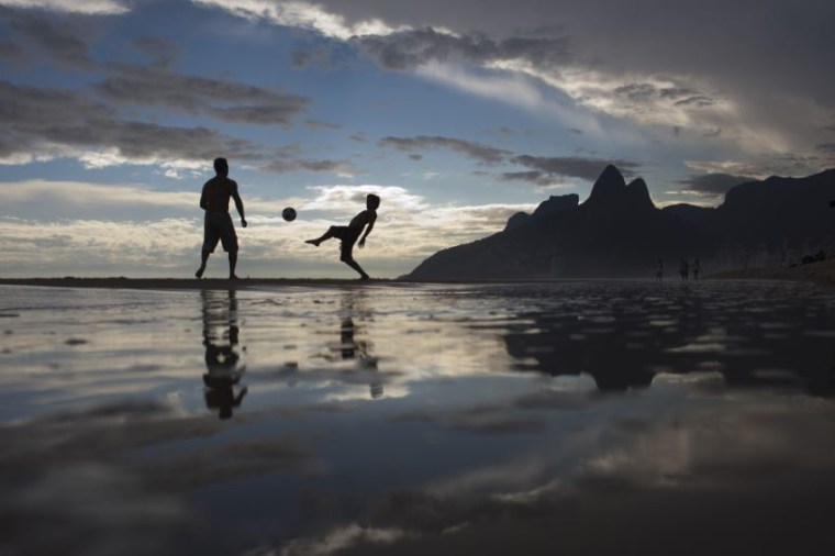 Men play soccer at Ipanema beach.