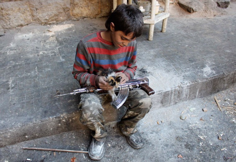 Mohammad plays with a cat in Aleppo's Bustan al-Basha district Oct. 28, 2013.