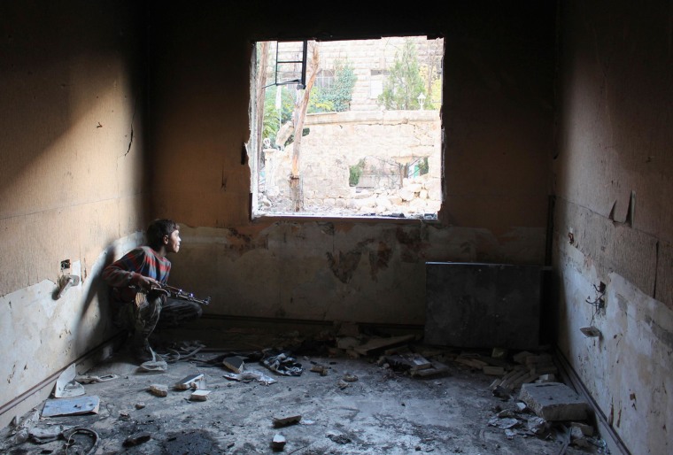 Mohammad takes cover inside a room in Aleppo's Bustan al-Basha district Oct. 28, 2013.