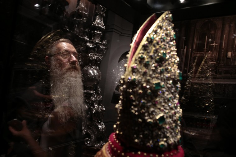 A visitor looks at the Mitre of San Gennaro during an exhibition in Rome on Oct. 29, 2013. One of the world's richest treasure troves went on display in Rome on Tuesday, including gem-studded chalices, sumptuous jewelry and golden trinkets collected over seven centuries.