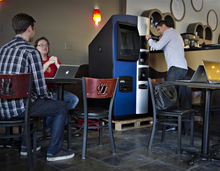 Vancouver Bitcoiniacs Trading Company co-founder Mitchell Demeter prepares, according to him, the first bitcoin ATM machine in a Waves Coffee House in...